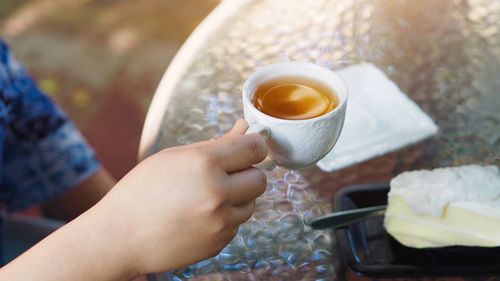 Cropped image of person holding coffee in early morning