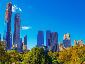 Panoramic view of modern buildings against blue sky