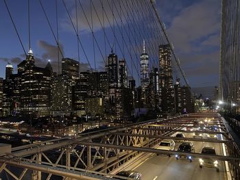 View of city lit up against cloudy sky