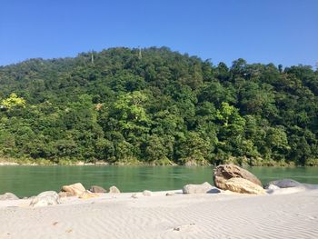 Scenic view of rocks by lake against sky