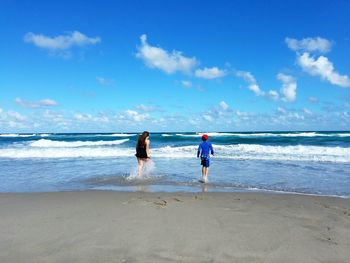 Rear view of two people on beach