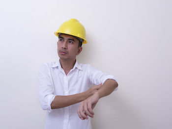 Portrait of young man standing against white background