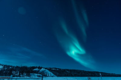 Scenic view of snow covered field against sky at night
