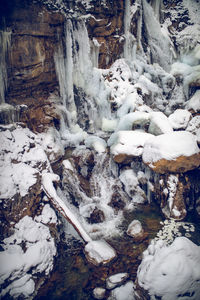 Frozen river flowing through snow