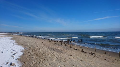 Scenic view of beach against blue sky