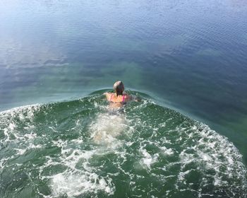 Rear view of boy swimming in sea