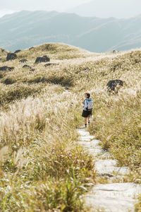 Rear view of person walking on trail