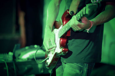 Midsection of man playing guitar