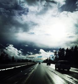 Country road against cloudy sky