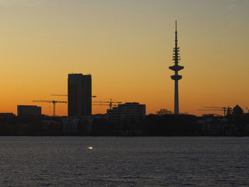 View of buildings at waterfront during sunset