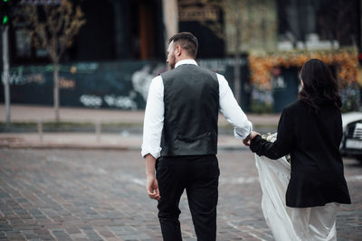 Rear view of couple walking on street