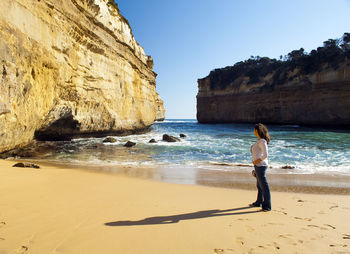 Woman looking away while standing at beach