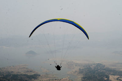 Person paragliding against sky