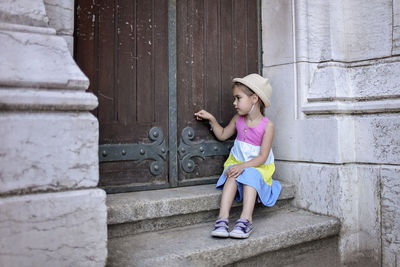 Girl touching door while on staircase