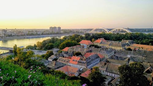 High angle view of buildings by river against sky