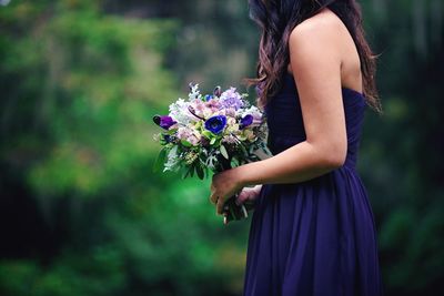 Side view of women holding flower bouquet