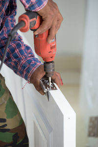 Cropped hand drilling wooden door