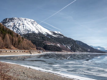 Scenic view of snowcapped mountains by sea against sky