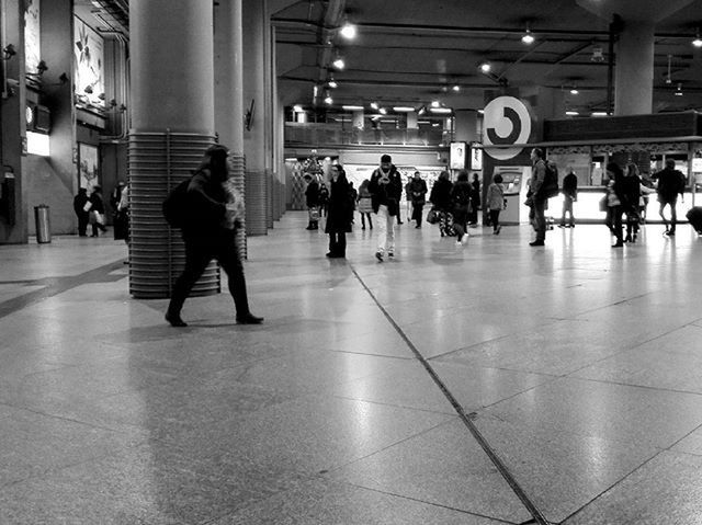 GROUP OF PEOPLE WALKING IN ILLUMINATED UNDERGROUND WALKWAY