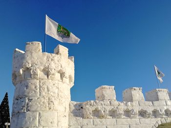 Low angle view of flag against blue sky