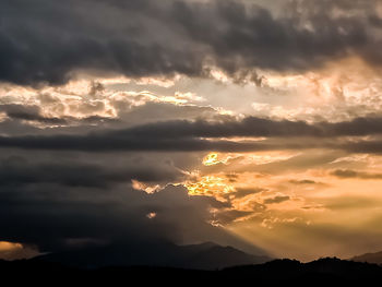 Scenic view of silhouette mountains against dramatic sky