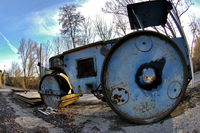 Old abandoned truck on road against sky