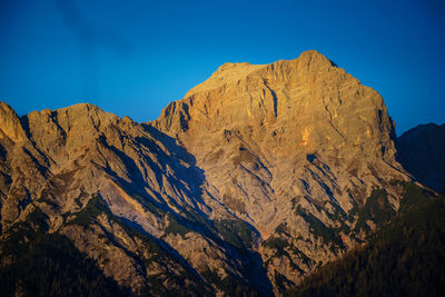 Scenic view of mountains against clear blue sky