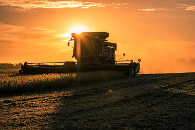 Scenic view of agricultural landscape against sky during sunset