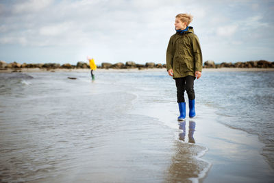 Full length of boy standing at beach