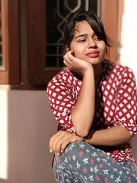 Portrait of a beautiful young woman sitting at home