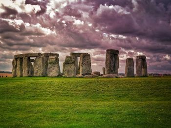 Built structure on landscape against cloudy sky