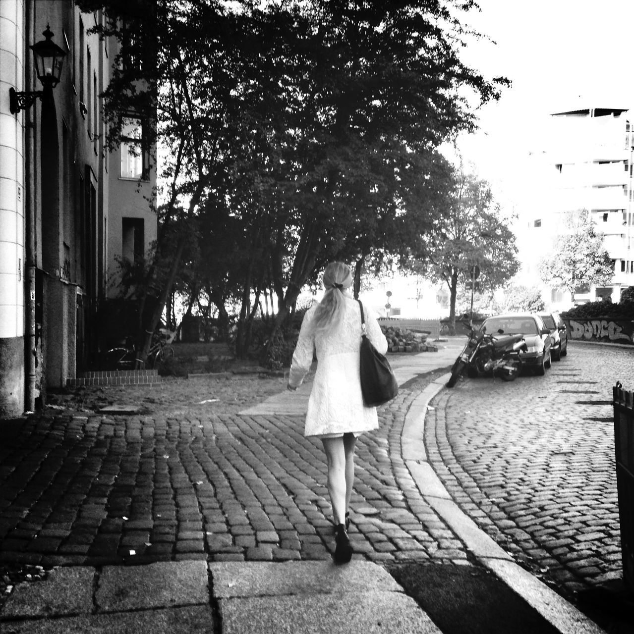 building exterior, architecture, built structure, street, city, rear view, sidewalk, walking, lifestyles, full length, cobblestone, city life, the way forward, tree, men, person, footpath, umbrella