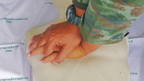 Cropped hands of paramedic practicing cpr on mannequin