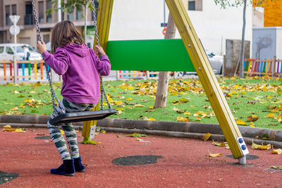 Girl playing on swing at playground