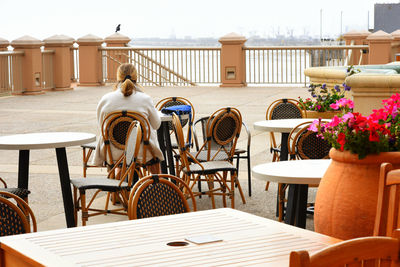 Rear view of woman sitting at sidewalk cafe