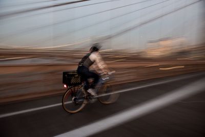 Blurred motion of man riding bicycle on sand