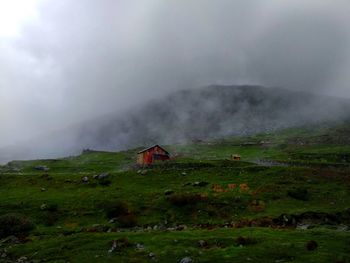 Mid distance of house on field against cloudy sky