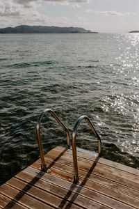 High angle view of hand rail on pier by sea