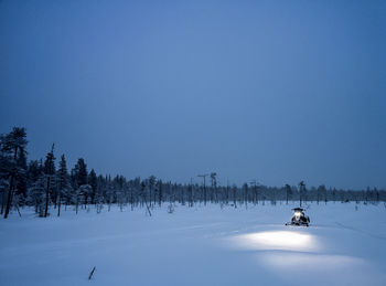 Snowmobile on field against sky at night