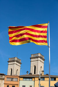 Low angle view of flags against blue sky