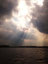 Scenic view of sea against cloudy sky during sunset