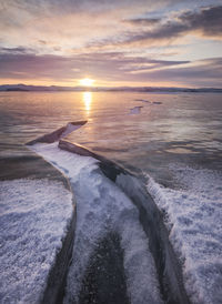 Big crack in the ice field at sunset