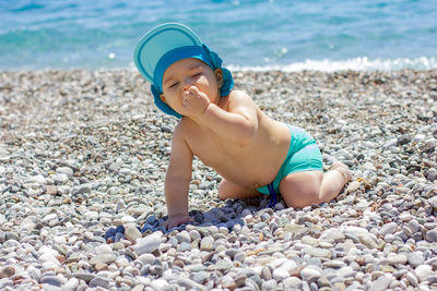 Boy playing on stones at beach