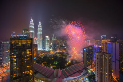 Scenic view of firework display over city at night