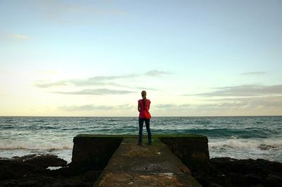 Rear view of woman standing on beach
