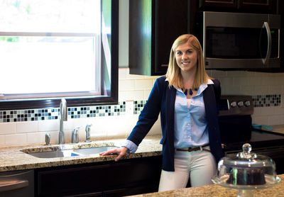 Portrait of woman standing in kitchen at home