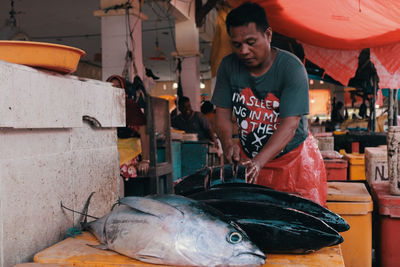 Rear view of man holding fish in market