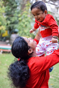 Loving mom carrying of her baby at society park. bright portrait of happy mum holding child