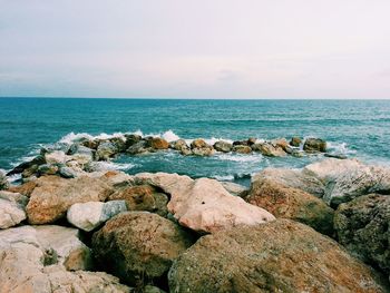 Rocks in sea against sky