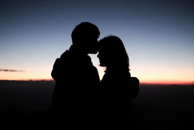 A couple are kissing on the peak